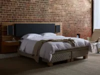 Bed with upholstered fabric and wood headboard by Duxiana