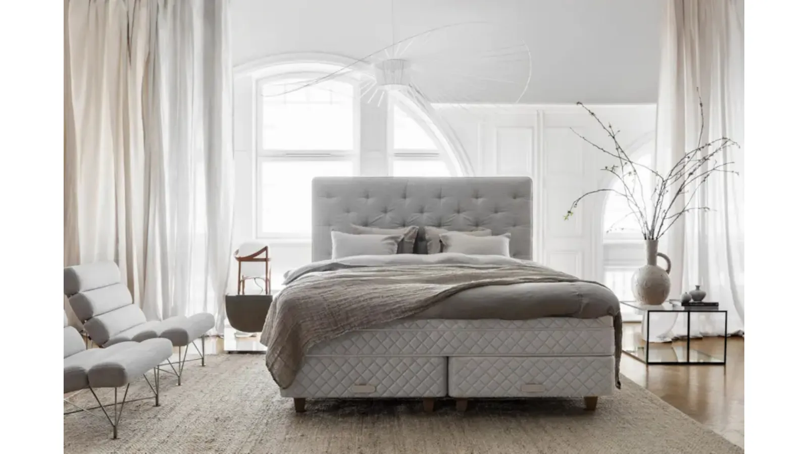 Bed with a Royal headboard in quilted and padded fabric by Duxiana