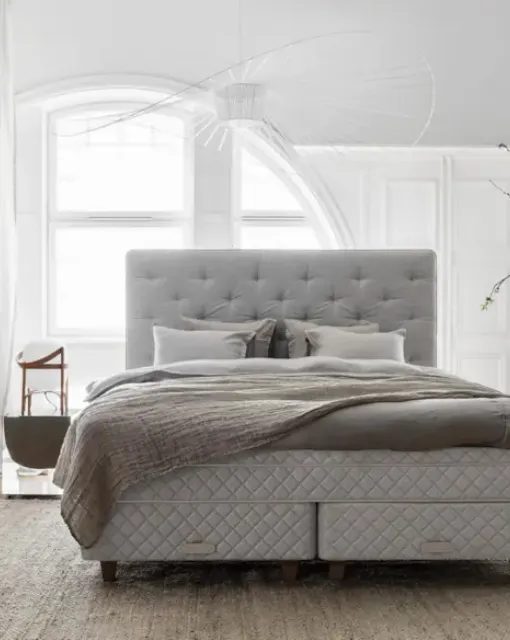 Bed with a Royal headboard in quilted and padded fabric by Duxiana